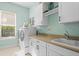 Bright laundry room with white cabinets and new appliances at 9044 Luna Ln, Sarasota, FL 34241