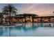 Community resort-style pool with lounge chairs at sunset at 9044 Luna Ln, Sarasota, FL 34241