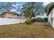 Fenced backyard with grassy area and mature trees at 1898 New Hampshire Ne Ave, St Petersburg, FL 33703