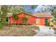 Bright orange house with covered patio and landscaped yard at 70 Horton Cir, Sarasota, FL 34232