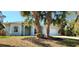 Newly constructed home with light gray exterior, two palm trees, and a spacious yard at 2559 Comet Ln, North Port, FL 34286