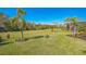 Expansive backyard featuring lush green grass, palm trees, and professional landscaping at 4606 Pond Brook Ct, Bradenton, FL 34211