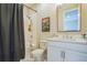 The cozy bathroom offers a shower-tub combination, a white vanity and ample lighting at 4606 Pond Brook Ct, Bradenton, FL 34211