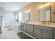 A stylish primary bathroom featuring double sinks, grey cabinetry, quartz countertops, and a walk-in shower at 4606 Pond Brook Ct, Bradenton, FL 34211