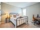 Comfortable bedroom featuring a metal-frame bed, neutral walls, and a dedicated workspace at 4606 Pond Brook Ct, Bradenton, FL 34211