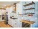 White kitchen with chevron backsplash, wine cooler, and wooden shelving at 4606 Pond Brook Ct, Bradenton, FL 34211