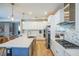 Bright kitchen featuring white cabinets, herringbone backsplash, and large island at 4606 Pond Brook Ct, Bradenton, FL 34211