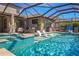 The pristine pool features a hot tub, sun loungers, covered patio, and a lush green backyard at 4606 Pond Brook Ct, Bradenton, FL 34211