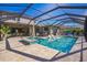 Private screened-in pool features a built-in hot tub, sun loungers, covered patio and a lush green backyard at 4606 Pond Brook Ct, Bradenton, FL 34211