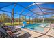 Beautiful screened-in pool with basketball hoop, sun loungers, patio umbrellas and a serene view at 4606 Pond Brook Ct, Bradenton, FL 34211