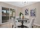 Dining area with four chairs, modern art, and sliding door to patio at 6201 Cedarbrook N Dr, Pinellas Park, FL 33782