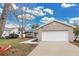 Tan house with white garage door, landscaped yard, and walkway at 6201 Cedarbrook N Dr, Pinellas Park, FL 33782