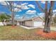 Tan house with white garage door and mature trees at 6201 Cedarbrook N Dr, Pinellas Park, FL 33782