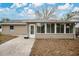 Tan house with a sunroom and concrete patio at 6201 Cedarbrook N Dr, Pinellas Park, FL 33782
