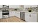 Modern white kitchen with stainless steel appliances and corner sink at 6201 Cedarbrook N Dr, Pinellas Park, FL 33782