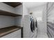 Laundry room with washer, dryer, and wood shelving at 3260 Wentworth St, North Port, FL 34288