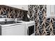 Laundry room with white appliances and a stylish palm wallpaper at 14517 Coastal Woodland Ln, Parrish, FL 34219