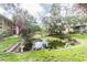 Tranquil pond in a community setting, featuring a wooden bridge and lush greenery at 5504 Pokeweed Ct # 154, Tampa, FL 33617