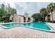 Sparkling community swimming pool with brick patio and surrounding trees at 5504 Pokeweed Ct # 154, Tampa, FL 33617