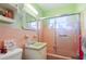 Retro bathroom with pink tile, shower/tub combo, and vanity at 6540 Marius Rd, North Port, FL 34287