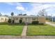 Cute ranch home with carport, nicely landscaped lawn, and walkway at 6540 Marius Rd, North Port, FL 34287