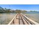 Wooden walkway over clear water leading to the main waterway at 103 Shore Dr, Dunedin, FL 34698