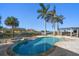 Relaxing kidney-shaped pool surrounded by palm trees and patio at 103 Shore Dr, Dunedin, FL 34698