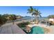 Inviting pool area with pergola, water access, and lush landscaping at 103 Shore Dr, Dunedin, FL 34698