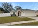 House exterior featuring a red door, attached garage and front yard at 1502 Silktree Ct, Brandon, FL 33511