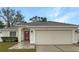 House exterior boasts a two-car garage and landscaped lawn at 1502 Silktree Ct, Brandon, FL 33511