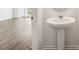 Clean bathroom with pedestal sink and view of adjacent room at 11864 Sylvia St, Dade City, FL 33525