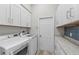 Bright laundry room with white cabinets and quartz countertop at 7419 Roxye Ln, Sarasota, FL 34240