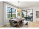 Dining room with wooden table and bench, and view of screened lanai and lake at 2546 Buckthorn Loop, North Port, FL 34289