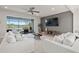 Open Gathering room with white sofas, a large TV, and sliding glass doors to a lanai at 2546 Buckthorn Loop, North Port, FL 34289