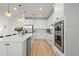 Bright kitchen featuring white cabinets, stainless steel appliances, and hardwood floors at 2546 Buckthorn Loop, North Port, FL 34289