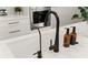 Close-up of a modern kitchen sink with black faucet and water filter at 2546 Buckthorn Loop, North Port, FL 34289