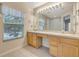 Double vanity bathroom with wood cabinets and window at 1006 Vista Cay Ct, Brandon, FL 33511