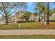 Tan townhome with a green lawn and trees at 1006 Vista Cay Ct, Brandon, FL 33511