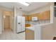Bright kitchen with light wood cabinets, white appliances, and tile floor at 1006 Vista Cay Ct, Brandon, FL 33511