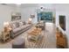 Bright living room with comfy seating, large TV, and sliding glass door to balcony at 705 S Village N Dr # 205, St Petersburg, FL 33716