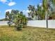 Landscaped backyard with lush tropical plants and a white vinyl fence at 407 Stone Briar Dr, Ruskin, FL 33570