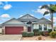 Attractive one-story home with a red garage door and landscaped yard at 407 Stone Briar Dr, Ruskin, FL 33570