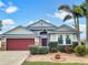 Attractive one-story home with a red garage door and landscaped yard at 407 Stone Briar Dr, Ruskin, FL 33570