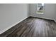 Simple bedroom with grey wood-look flooring and a window view at 4739 Butler National Dr, Wesley Chapel, FL 33543