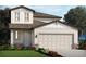 Two-story house with stone accents, two-car garage, and landscaping at 1852 Brekey Way, Zephyrhills, FL 33541