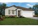 One-story home with a two-car garage, landscaping, and stone accents at 1875 Draughton Dr, Zephyrhills, FL 33541