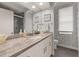 Modern bathroom with granite countertop, white cabinets, and patterned wall at 6720 The Masters Ave, Lakewood Ranch, FL 34202