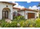 Front entry with double doors, landscaping, and a brown garage door at 6720 The Masters Ave, Lakewood Ranch, FL 34202