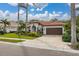 Single-story home with brown garage door, landscaped yard, and tile driveway at 6720 The Masters Ave, Lakewood Ranch, FL 34202