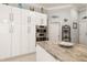 Modern white kitchen with stainless steel appliances and ample storage at 6720 The Masters Ave, Lakewood Ranch, FL 34202